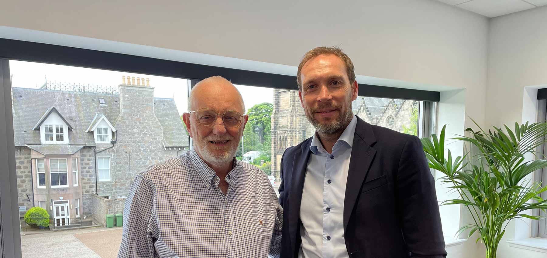 Phil McKenzie of Fowler McKenzie with Russell Anderson celebrating enhanced support for the Russell Anderson Foundation.