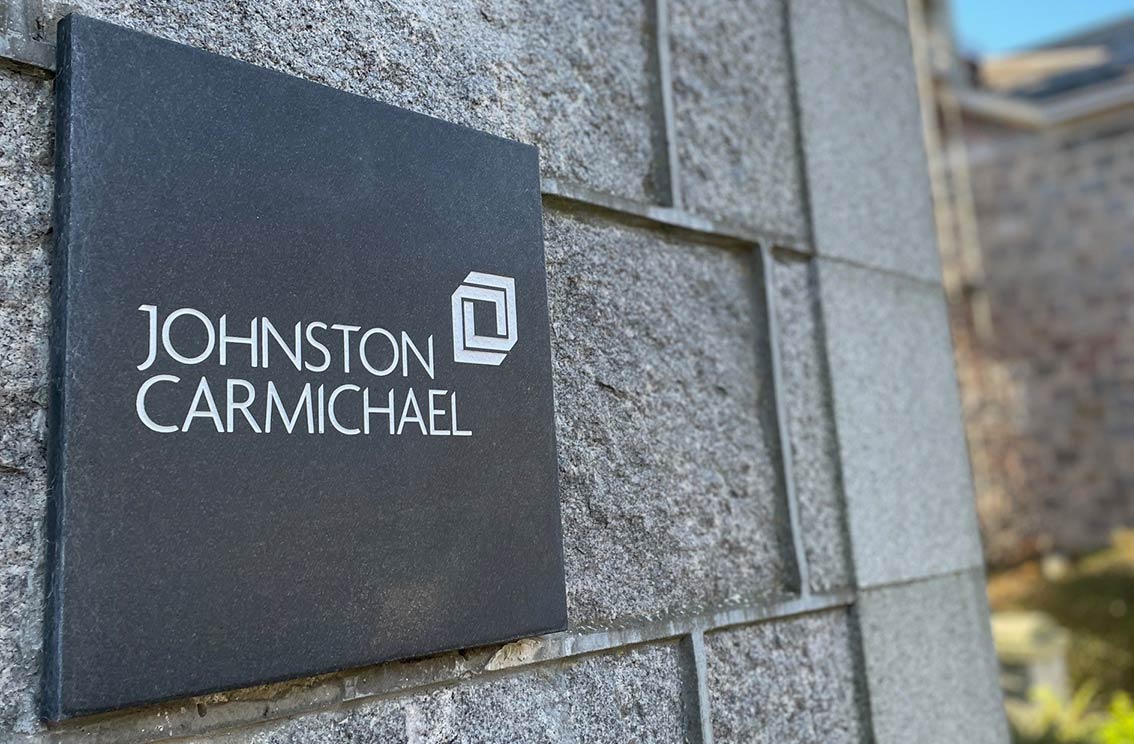 An image of The Johnston Carmichael Logo on a wall